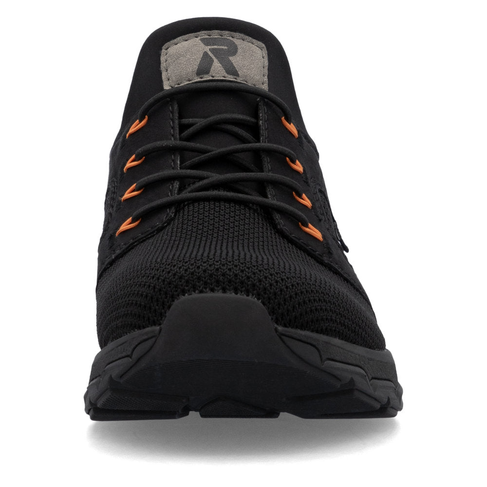 Black sneaker with orange accents and a grey patch with a logo.