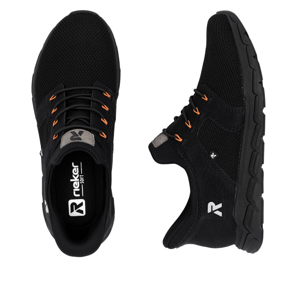 A pair of black shoes with orange accents and visible 'Rieker Soft' text inside one shoe.