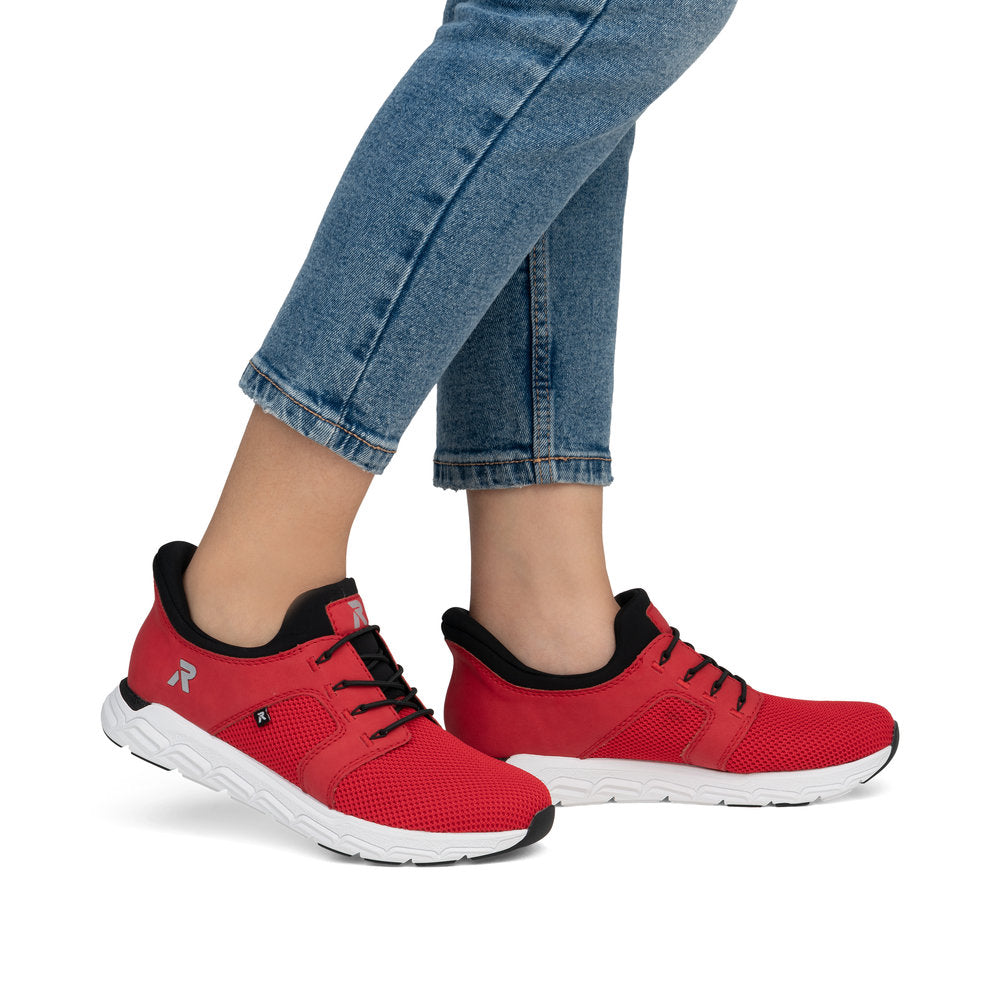 A pair of red athletic shoes with white soles, black laces and black lining.