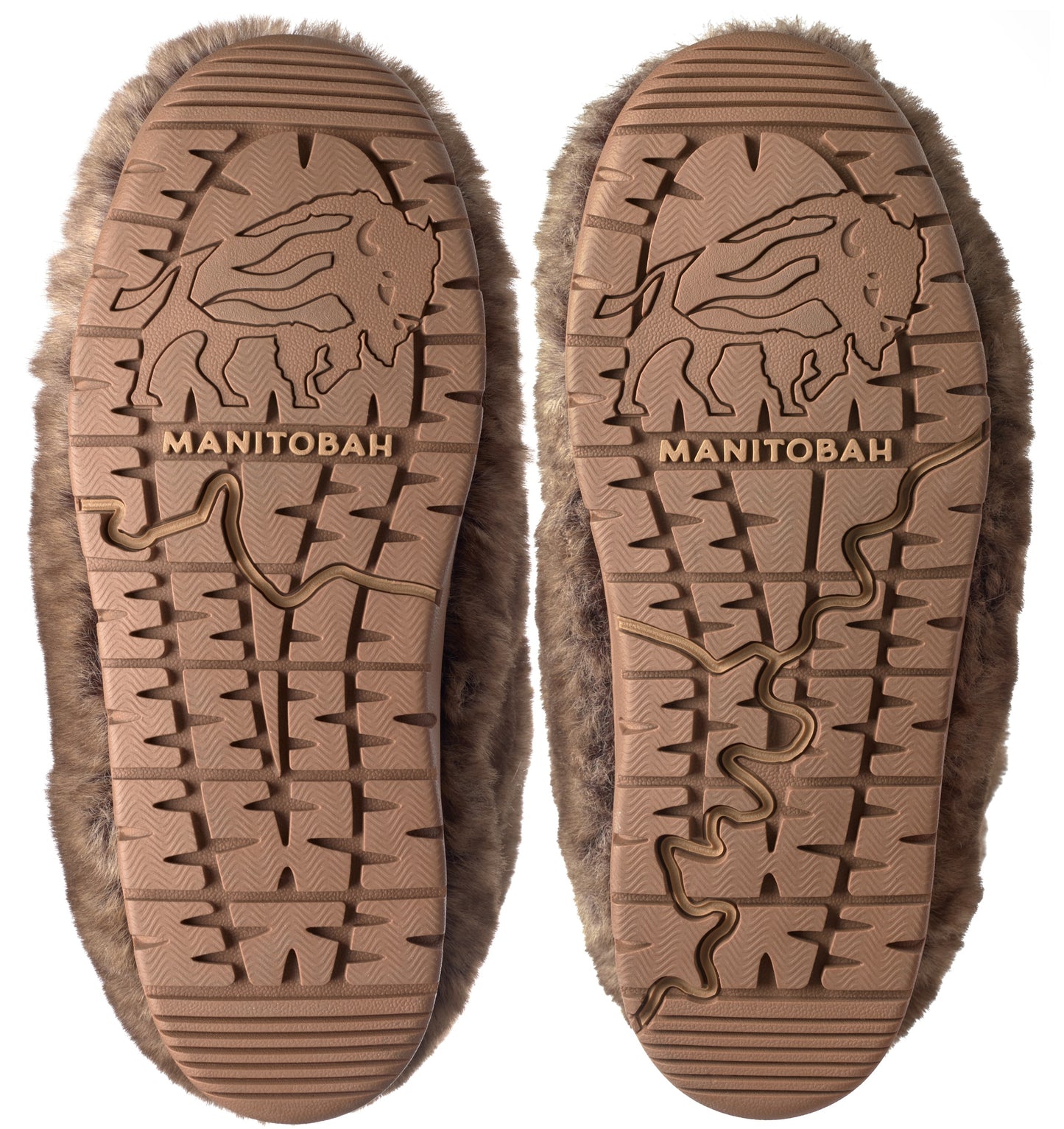 Close-up of the soles of two fuzzy moccasin slippers with bison logo and 'Manitobah' text.