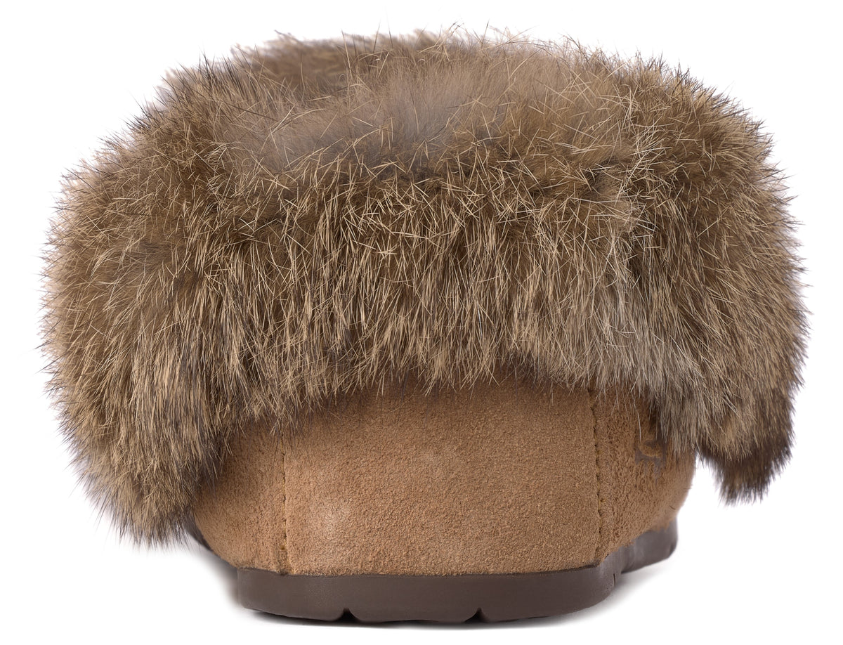A back view of a tan suede slipper featuring a thick, fluffy brown fur trim around the ankle collar and a dark brown rubber sole.