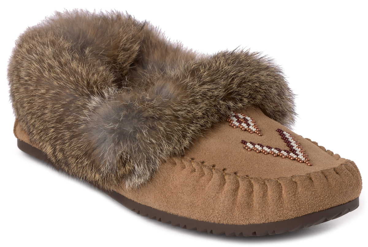 A tan suede moccasin-style slipper with a thick brown rabbit fur collar, featuring a geometric beadwork design on the vamp and a whip-stitched edge.