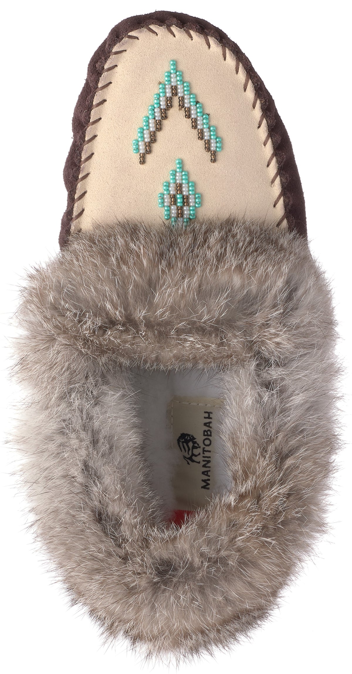 A tan suede moccasin with fluffy gray faux fur trim around the opening, featuring a geometric bead pattern in teal, white, and brown on the toe, with a 'MANITOBAH' label visible inside.