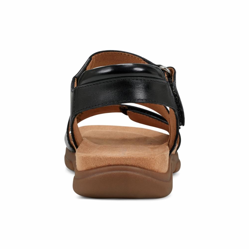 Black sandal with velcro strap and brown sole, rear view.