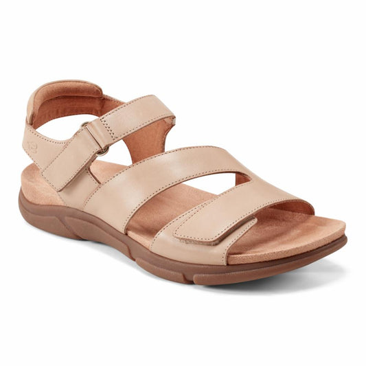 Beige sandal with adjustable straps and a low, brown sole.