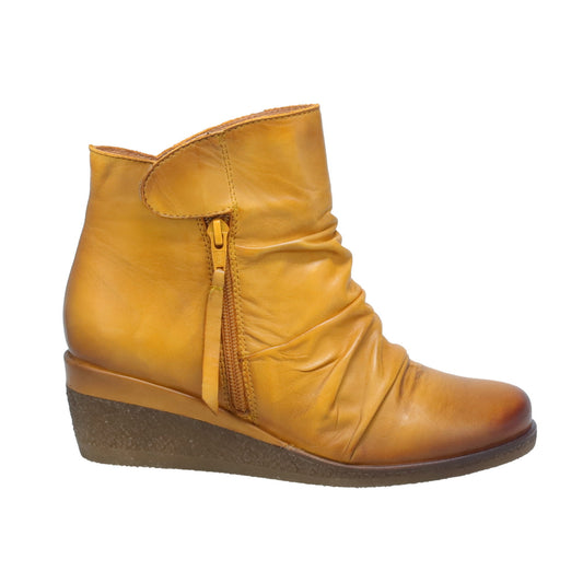 Mustard-colored leather ankle boot with side zipper and a low wedge heel.