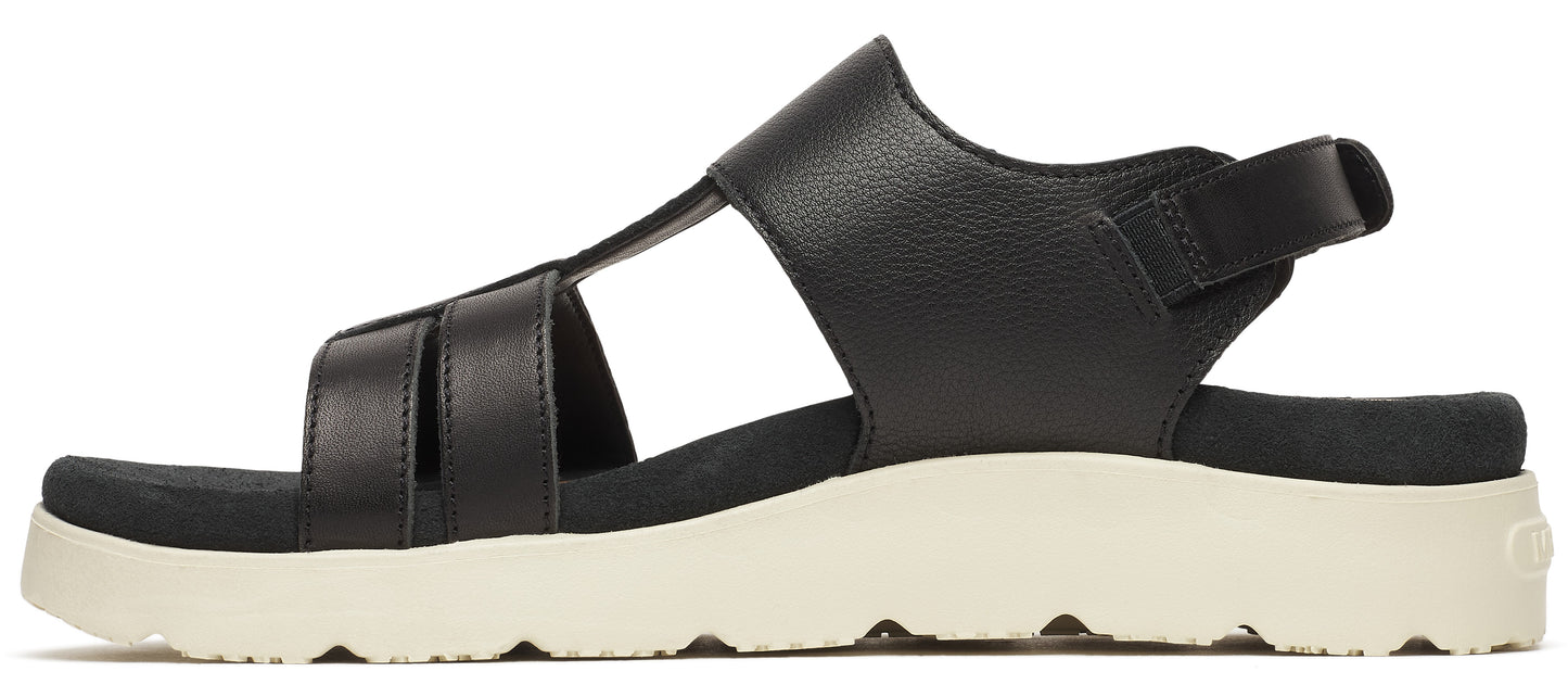 A black sandal with a thick white sole and an ankle strap.