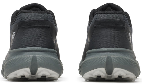 Rear view of two dark grey running shoes showing the sole, which has a grey top with a white bottom, and a black upper with a tab.