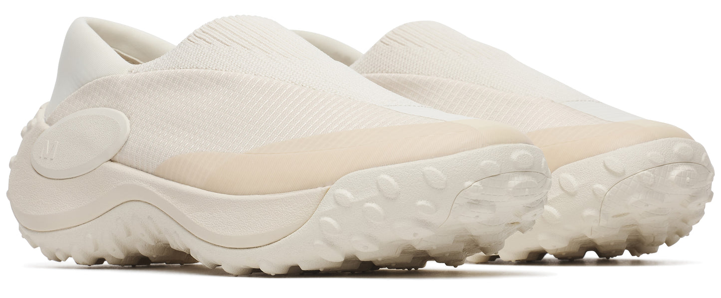 Pair of beige slip-on shoes with thick soles and textured detailing.