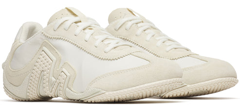 Off-white sneakers with suede and textile uppers and a patterned sole.