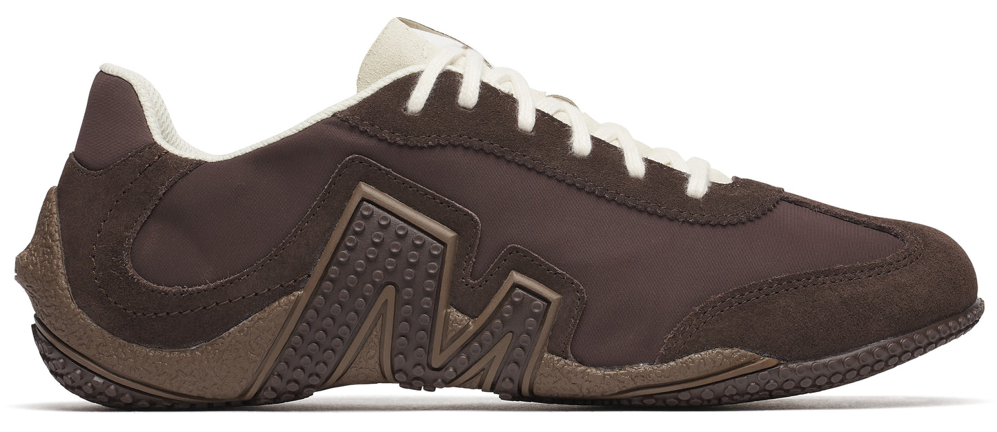 A brown sneaker with a white sole and laces.