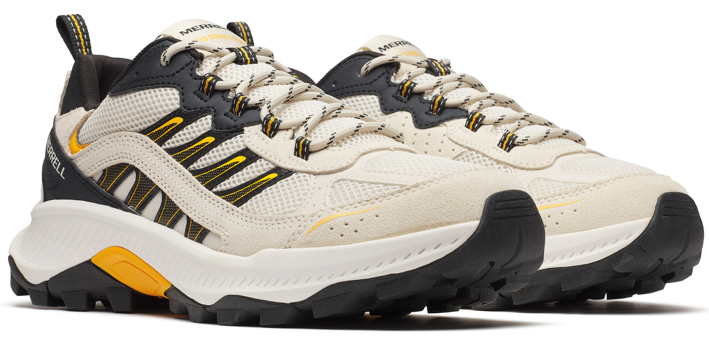 Pair of hiking shoes featuring cream uppers with black and yellow accents and a rugged sole.