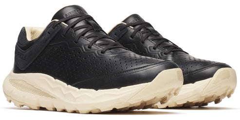 A pair of low-profile black leather shoes with a light beige jagged sole, lace-up closure, and perforated sides.