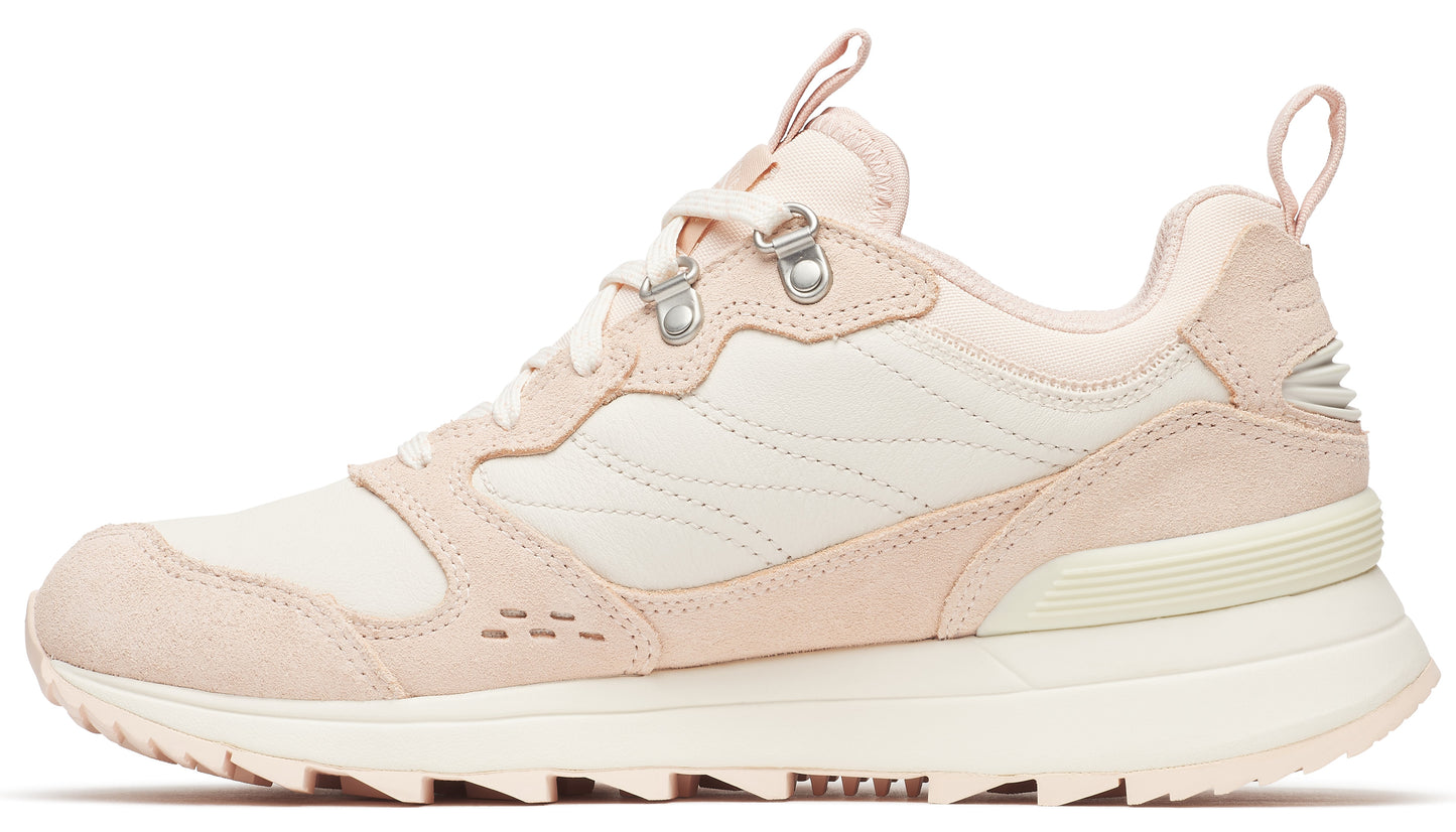 Side view of a pink and cream low-top trail shoe with metal eyelets and a lugged sole.