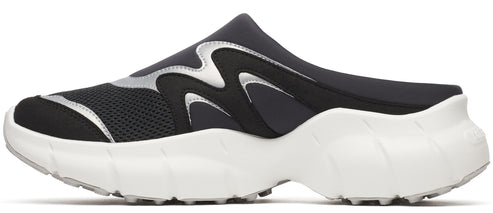 A black slip-on shoe with silver detailing and a white sole.