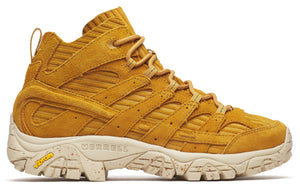 Mustard suede hiking boot with beige midsole, corded details, and visible MERRELL and Vibram logos.