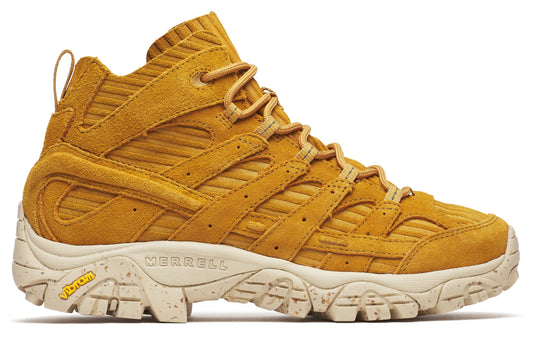 Mustard suede hiking boot with beige midsole, corded details, and visible MERRELL and Vibram logos.