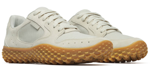 A pair of light beige sneakers with tan honeycomb pattern soles.