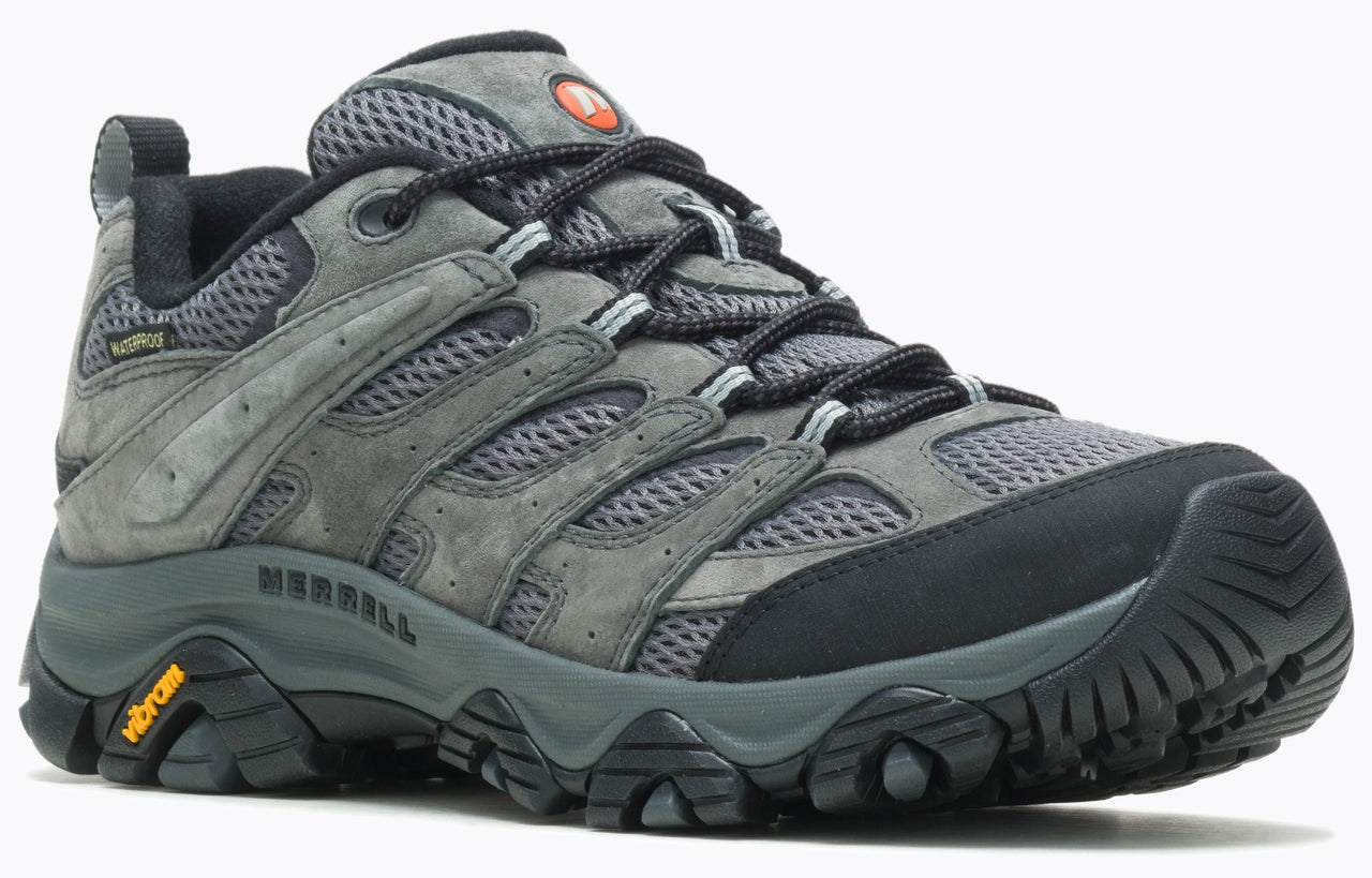 A grey hiking shoe with a thick black sole and black laces.