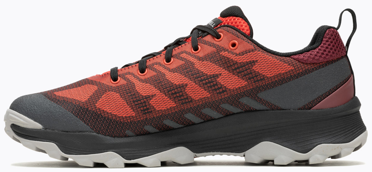 A red and black running shoe with a lace-up closure and a rugged sole.