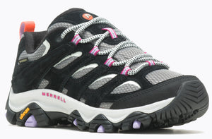 A black and gray hiking shoe with Vibram sole, featuring pink accents on the eyelets and a Merrell logo.