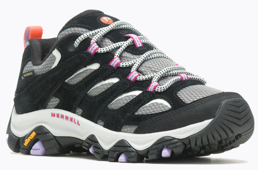 A black and gray hiking shoe with Vibram sole, featuring pink accents on the eyelets and a Merrell logo.