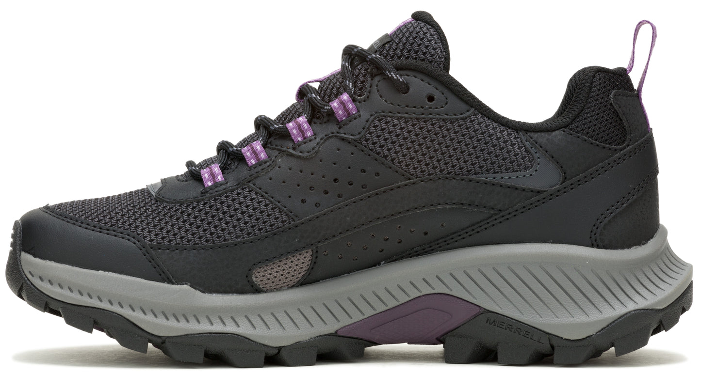 Side view of a gray and black athletic shoe with purple accents and a lug sole.
