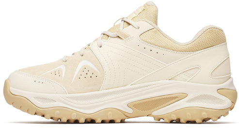 Beige sneaker with a lug sole, padded tongue, and layered panels.