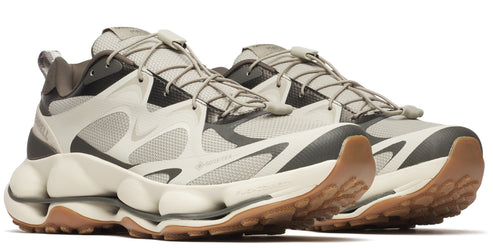 Pair of athletic sneakers with neutral tones and brown soles.
