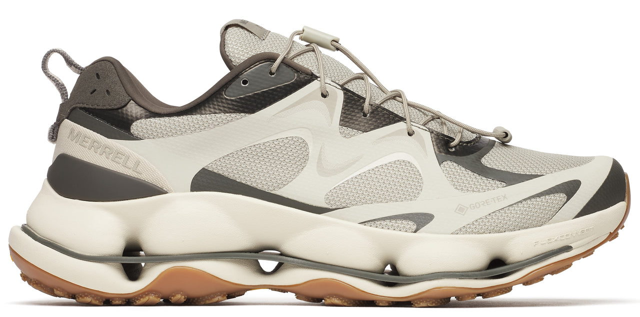 A hiking shoe with a taupe upper, brown trim, and a bulky white sole with cutouts.