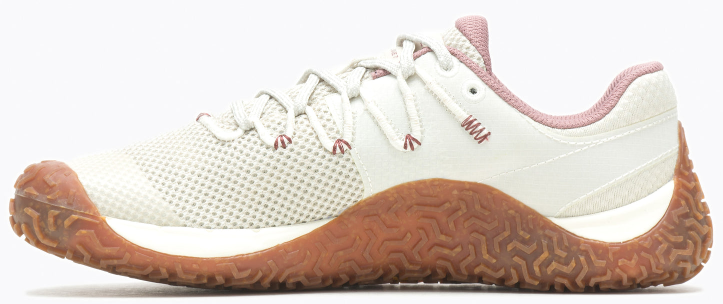 A women's off-white training shoe with a brown sole and pink trim.