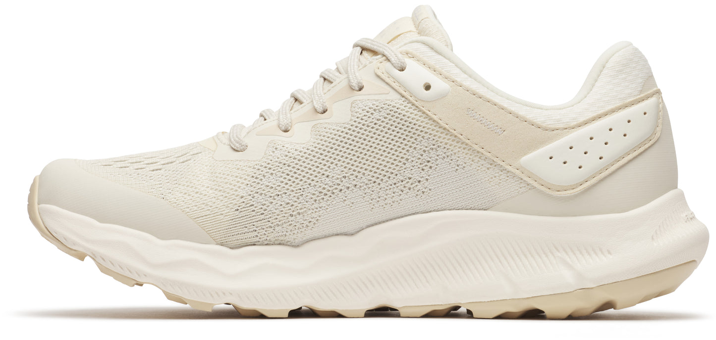 Beige athletic shoe with a mesh upper and thick white sole.