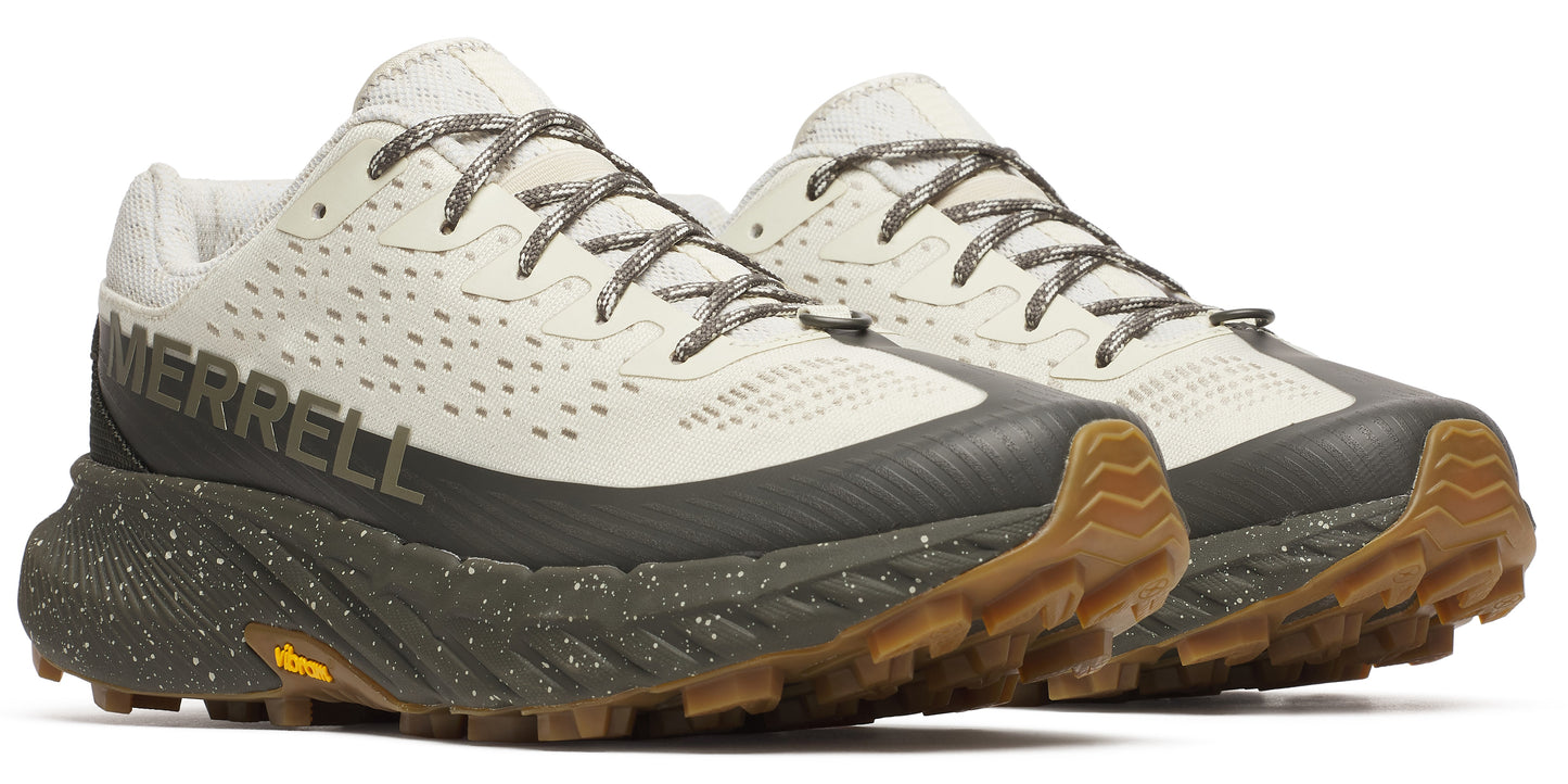 Pair of trail running shoes with tan uppers and speckled dark green soles.
