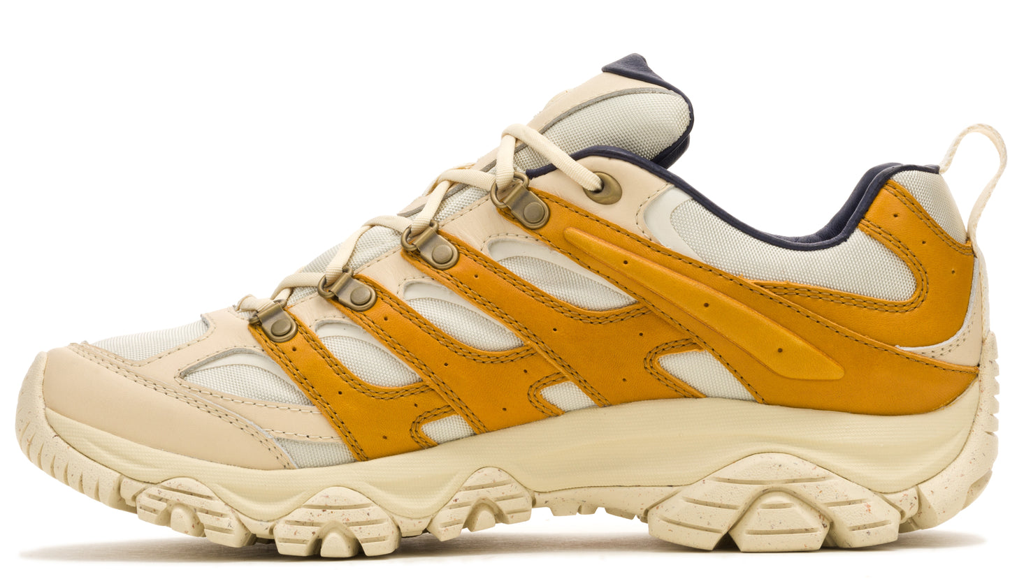 Side view of a low-cut off-white trail shoe with yellow accents, lace-up closure, and rugged sole.