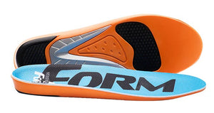 A pair of orange and light blue shoe insoles, with the top insole displaying the text FORM in large black letters and the bottom insole showing the textured support structure of the underside.