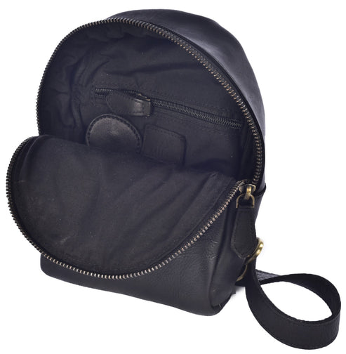 An open black leather mini backpack showing the interior lining, a zippered pocket on the back wall, and a black strap attached to the side.