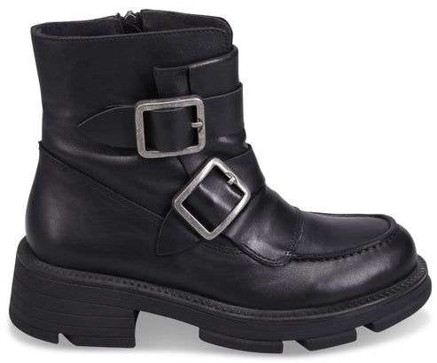 Black ankle boot with silver buckles and thick lug sole.
