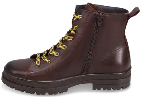 A brown leather ankle boot with a rugged, lugged sole, side zipper, and yellow and brown patterned laces.