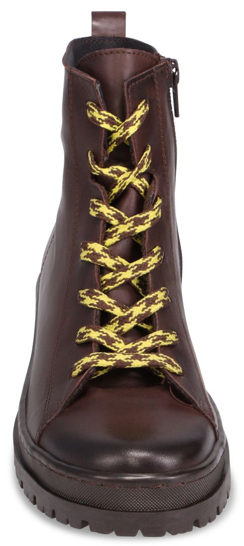 A brown ankle boot featuring a chunky, lugged platform sole, a side zipper, and yellow-and-black patterned laces.