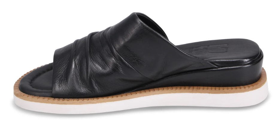 A black leather slide-on sandal with a flat white sole.