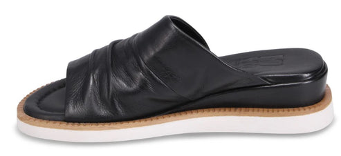 A black leather slide-on sandal with a flat white sole.