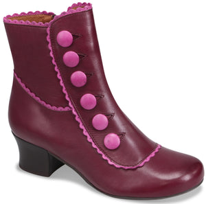 A maroon ankle boot with a low heel, featuring decorative bright pink scalloped trim along the top and side seams, and a vertical row of six matching bright pink buttons along the outer side.