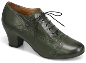 A dark olive green leather oxford style shoe with a block heel, featuring decorative brogue perforated details along the side and toe cap, and black lace-up closure.