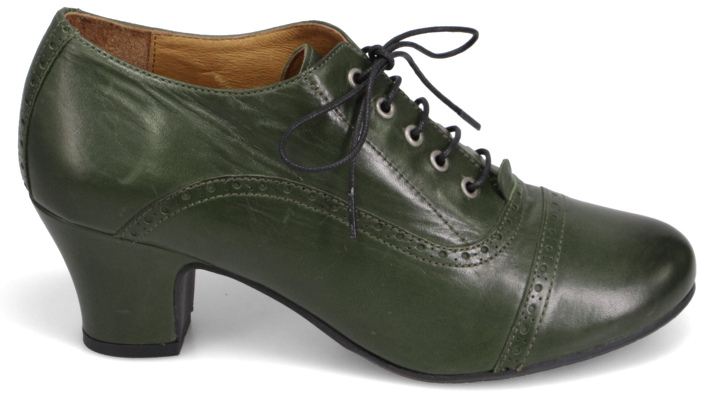 A dark olive green vintage-style oxford heel with decorative brogue detailing on the side and toe, featuring a lace-up front with black laces and a mid-height block heel.