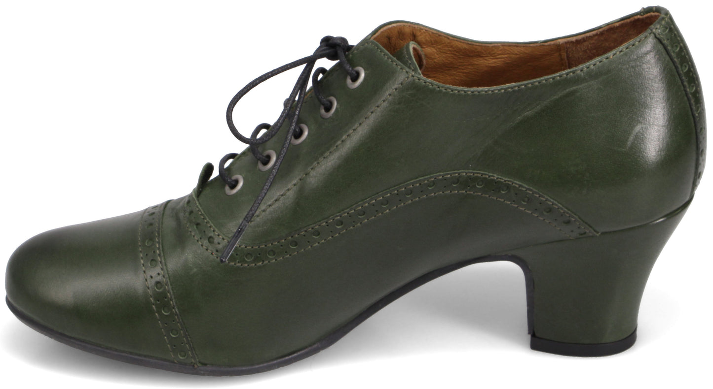 A dark olive green leather oxford-style heel with a round toe, lace-up front, and decorative brogue detailing across the toe cap and along the side panel.