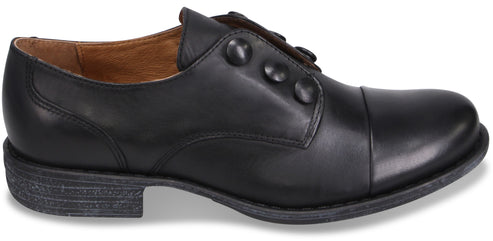A black leather dress shoe with a side button closure, a cap toe, and a low, stacked heel.