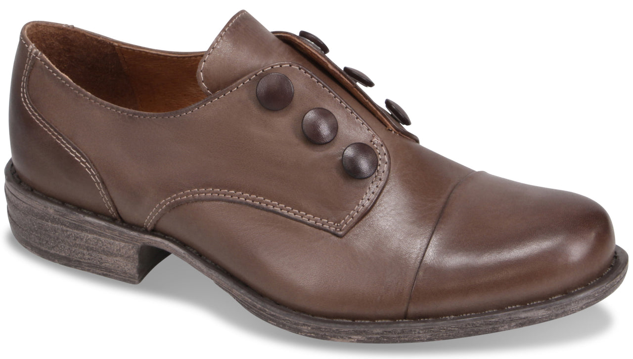 A brown leather cap-toe shoe with a low heel and three decorative buttons along the side.