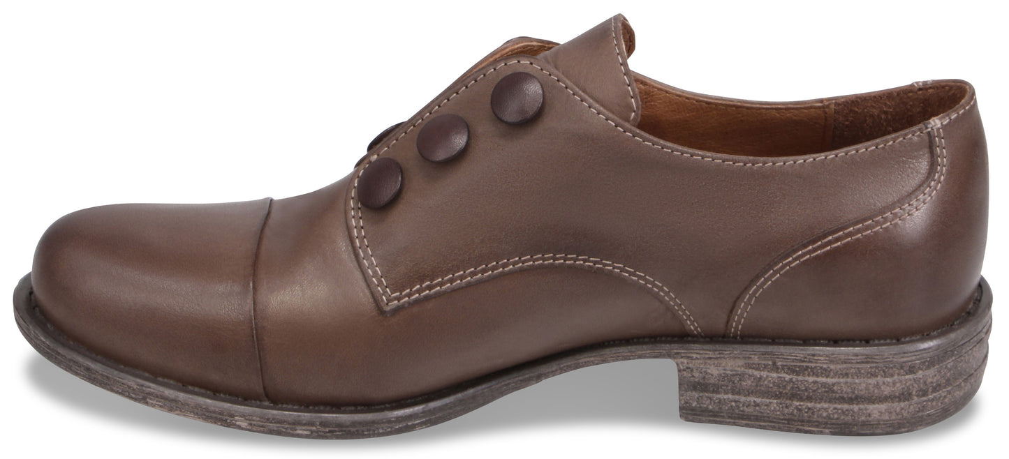 A brown leather dress shoe in profile, featuring a rounded toe cap, white contrast stitching along the quarter and heel, and three brown decorative buttons on the side.
