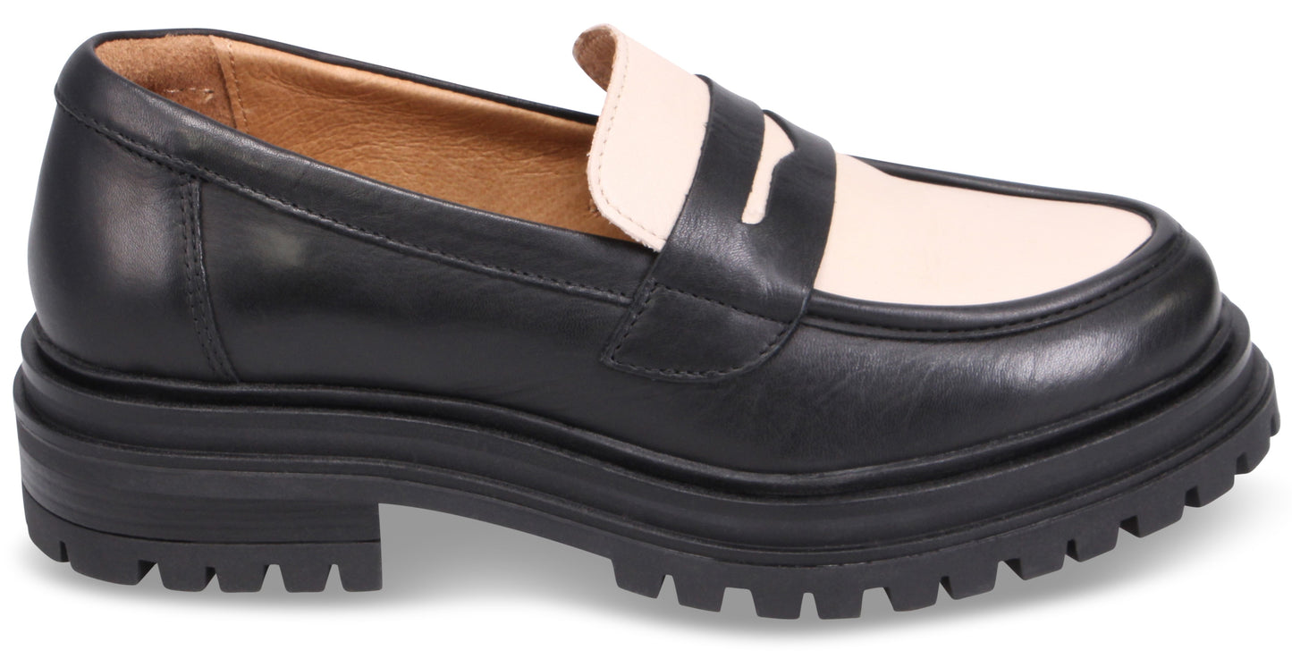 A black and beige two-tone leather loafer with a chunky black lug sole.