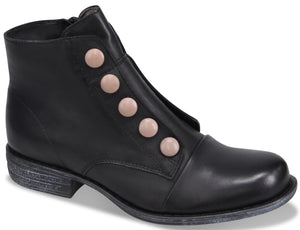 A black ankle boot with five round, light pink buttons along the front closure and a distressed-look low sole.